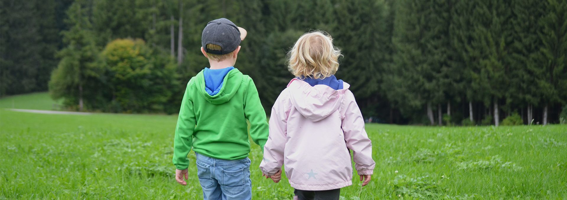 Kinder laufen über die Wiese